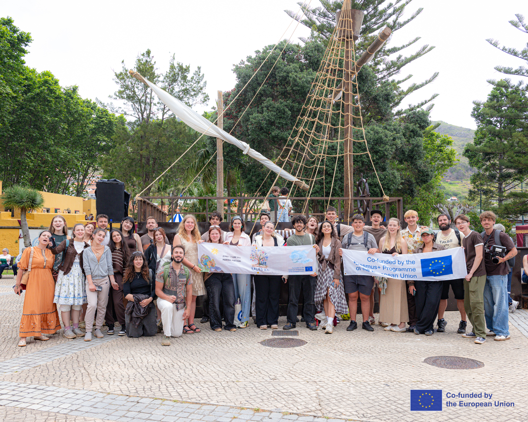 Group of young people posing with a project banner outdoors